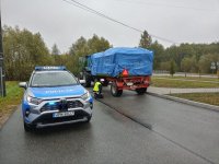 Policjanci z Wydziału Ruchu Drogowego podczas kontroli ciągnika rolniczego z przyczepą