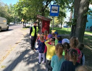 Spacer ulicami Hajnówki. Policjantka tłumaczy dzieciom zasady bezpiecznego poruszania się po drodze.
